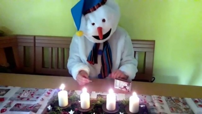 Ein Schneemann zündet vier Kerzen an